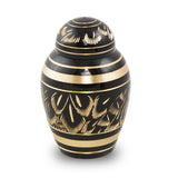 Beautiful black and gold small keepsake urn for ashes with radiant etchings revealing an intricate pattern that resembles feathers.