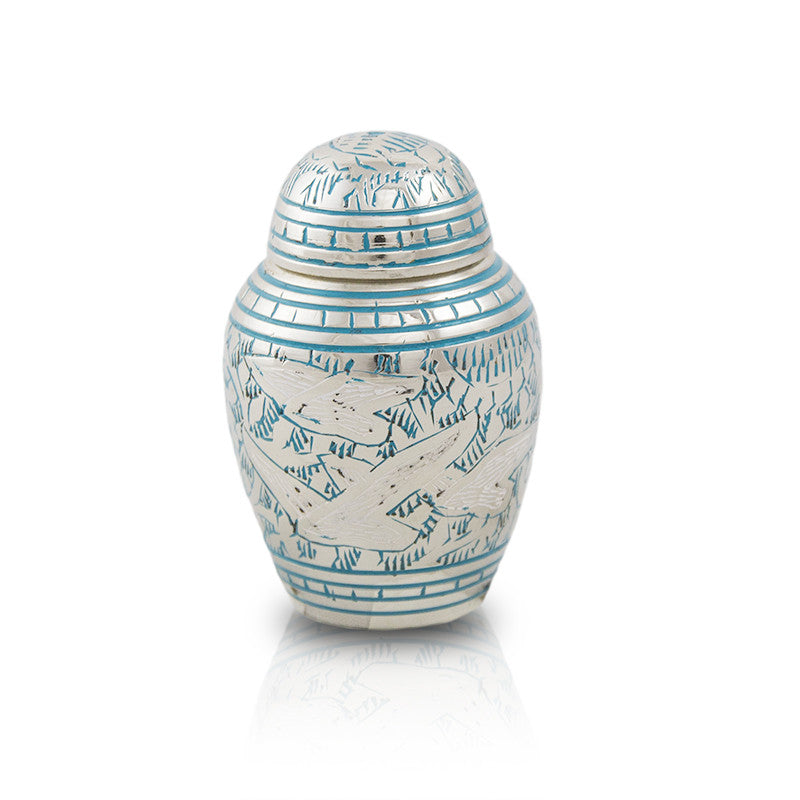 Small keepsake urn for human ashes with intricate etched pattern of doves in flight with blue paint fill.