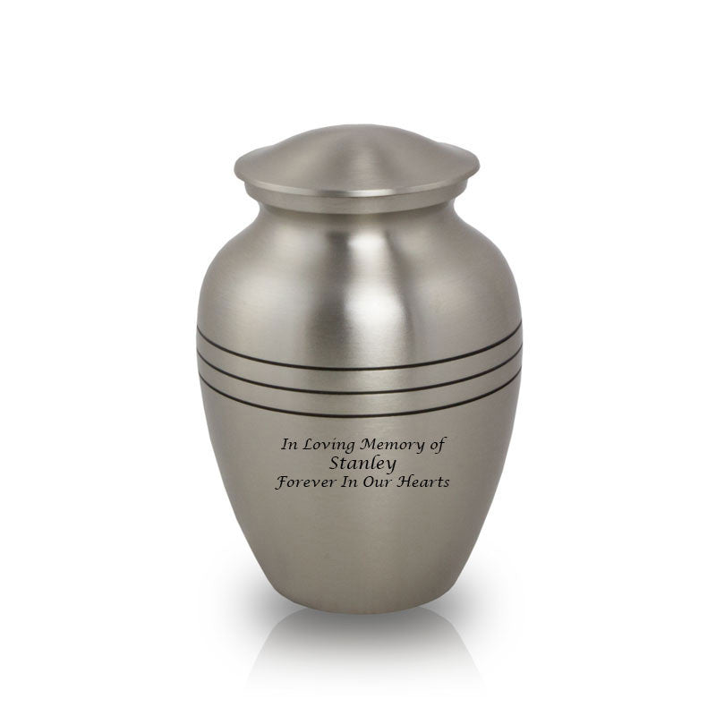 Small pewter colored cremation urn for ashes, made of brass and featuring sample engraved text.