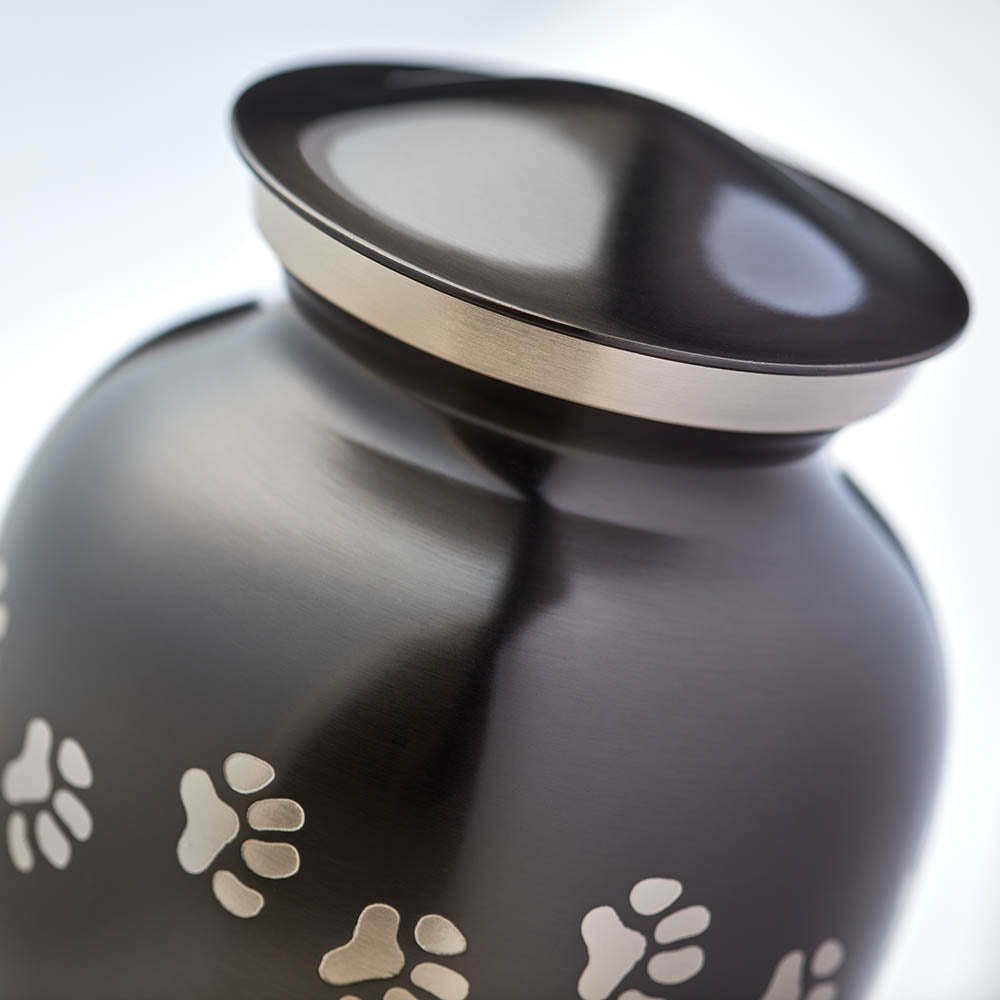 Slate grey pet urn with etched pewter paw prints detail image.