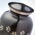 Slate grey pet urn with etched pewter paw prints detail image.