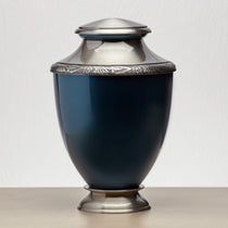 Aluminum cremation urn with pewter-plated brass lid and base featuring a glossy indigo finish and floral pewter band lifestyle.