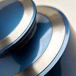Modern metal urn in a dark blue, shimmery finish with pewter accents detail image.