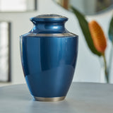 Modern metal urn in a dark blue, shimmery finish with pewter accents lifestyle.