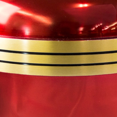 Red urn with metallic finish and three golden colored bands around the outside of the item.
