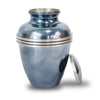 Urn for ashes with metallic blue finish and threaded lid leaning against side of item.