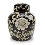 A black ceramic cremation urn with white lotus and vine patterns on the exterior in the chinoiserie style and ginger jar shaped urn.