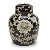 A black ceramic cremation urn with white lotus and vine patterns on the exterior in the chinoiserie style and ginger jar shaped urn.